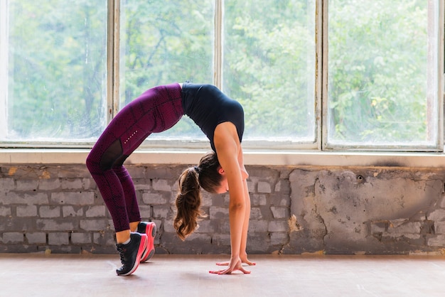 Gratis foto zijaanzicht van sportieve fit jonge vrouw in sportkleding uit te werken