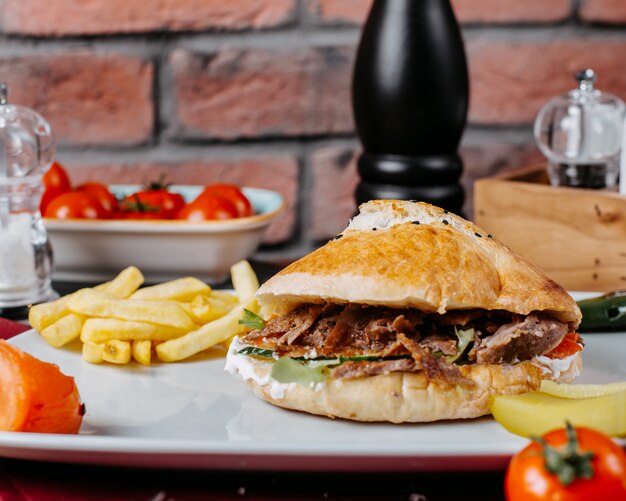 Zijaanzicht van Turkse donerkebab met frieten op een plaat