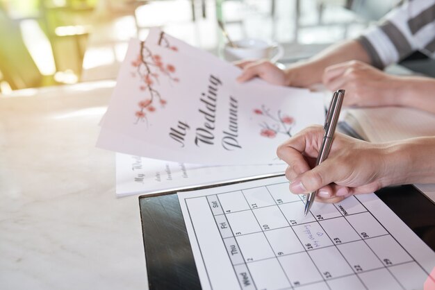 Zijaanzicht van twee onherkenbare mensen die hun trouwdag plannen