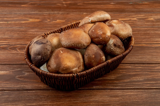 Zijaanzicht van verse paddestoelen in een rieten mand op houten plattelander