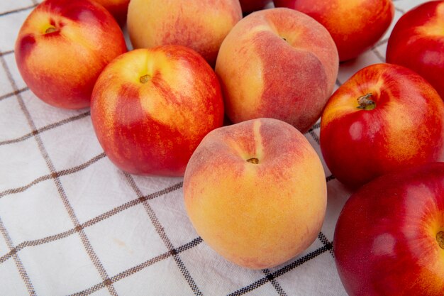 zijaanzicht van verse rijpe nectarines en perziken op geruite stoffen tafel