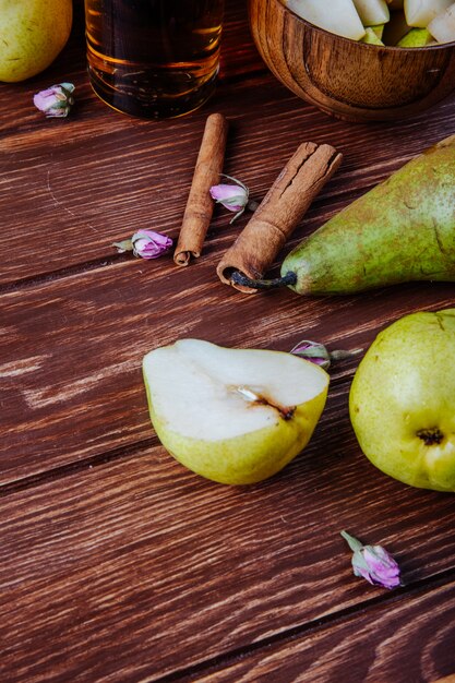 Zijaanzicht van verse rijpe peren en pijpjes kaneel op een houten achtergrond