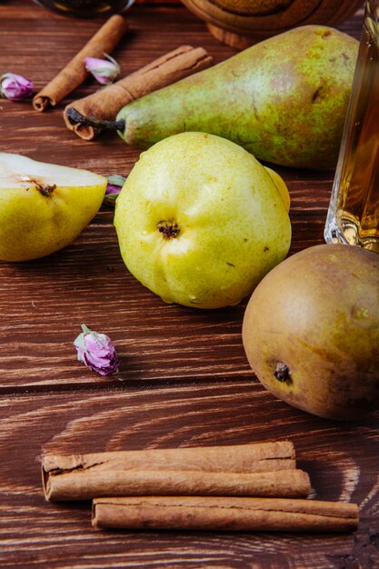 Zijaanzicht van verse rijpe peren en pijpjes kaneel op een houten achtergrond