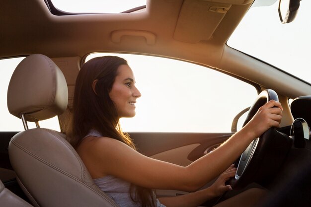 Zijaanzicht van vrouw auto buiten rijden