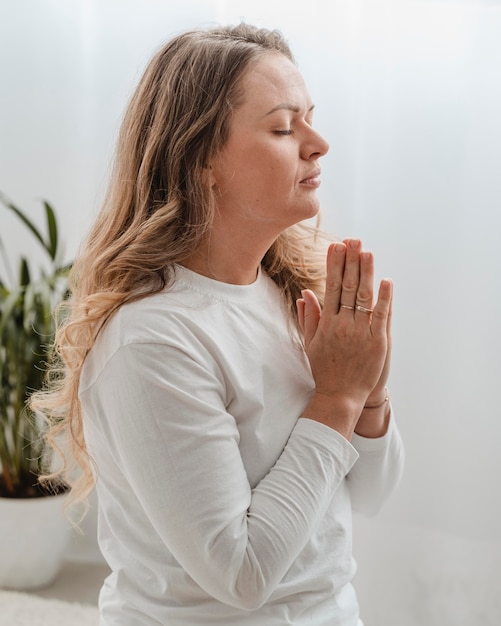 Gratis foto zijaanzicht van vrouw bidden