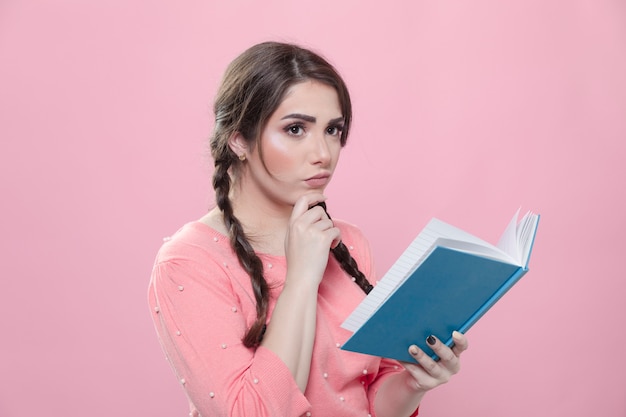 Zijaanzicht van vrouw die en boek denkt houdt