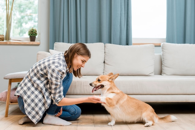 Zijaanzicht van vrouw die om de poot van haar hond vraagt