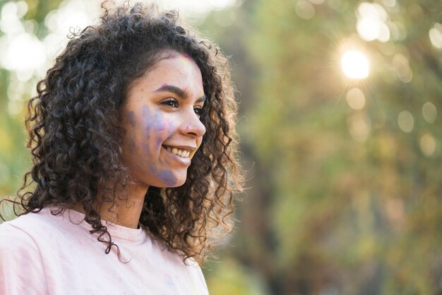 Zijaanzicht van vrouw met blauwe verf op haar gezicht