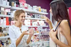 Gratis foto zijaanzicht van vrouwelijke adviseur die klant helpt met keuze in de winkel
