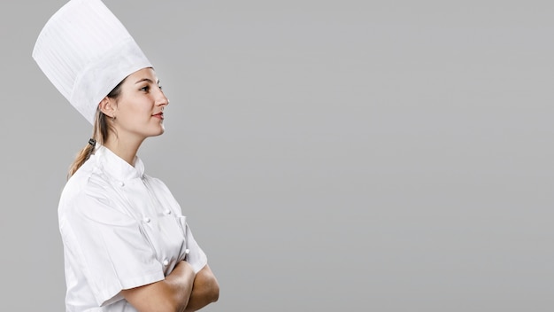 Gratis foto zijaanzicht van vrouwelijke chef-kok met exemplaarruimte