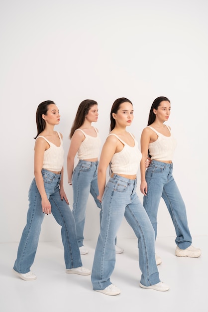 Zijaanzicht van vrouwen in tanktops en jeans poseren in minimalistische portretten