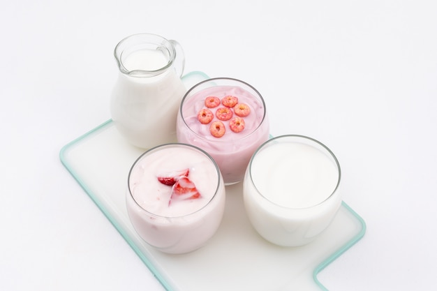 Zijaanzicht van yoghurt en melk op witte horizontale oppervlakte