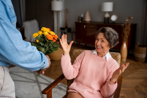 Gratis foto zijaanzicht verraste vrouw die bloemen ontvangt