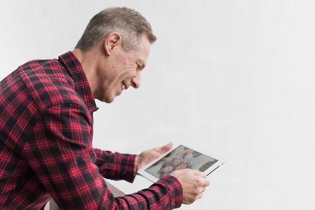 Zijaanzicht volwassen man op zoek op foto's met zijn kinderen en kleinkinderen