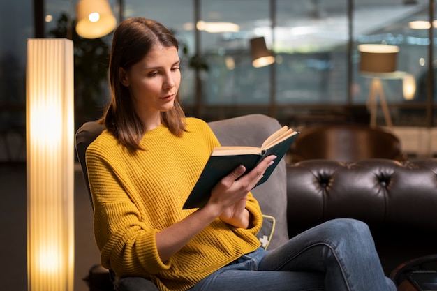 Zijaanzicht vrouw lezen binnenshuis