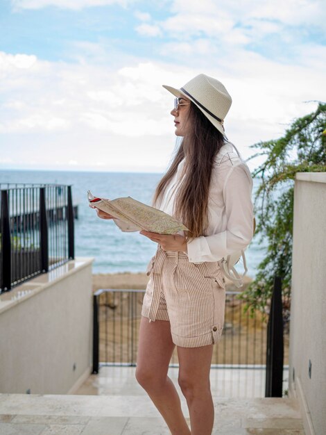 Zijaanzicht vrouw met kaart aan zee