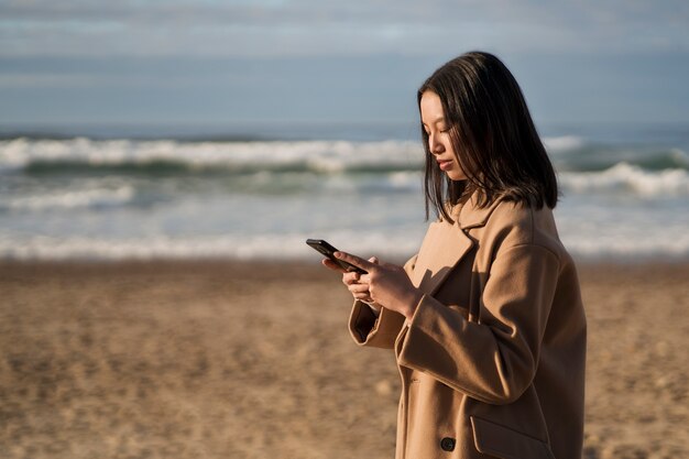 Gratis foto zijaanzicht vrouw met smartphone