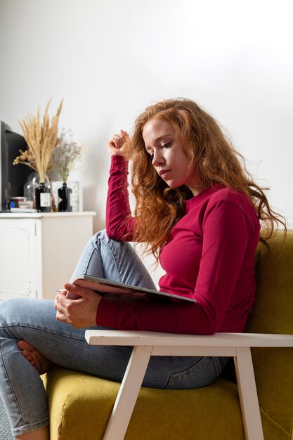 Zijaanzicht vrouw op bank lezen