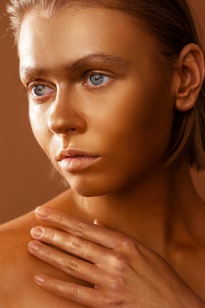 Zijaanzicht vrouw poseren met gouden bodypainting