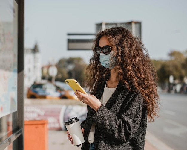 Gratis foto zijaanzicht vrouw te wachten in het busstation