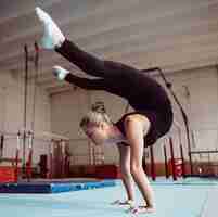 Gratis foto zijaanzicht vrouw training voor olympische gymnastiek