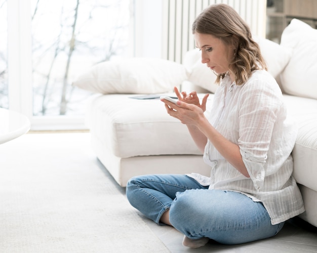 Zijaanzicht vrouw zittend op de vloer