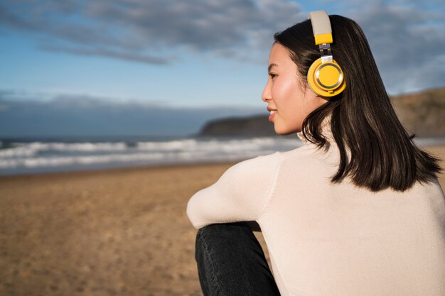 Zijaanzicht vrouw zittend op het strand