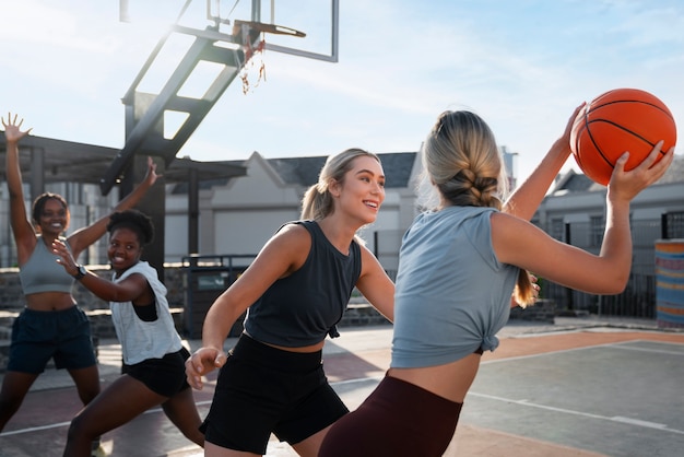 Zijaanzicht vrouwelijke vrienden die basketbal spelen