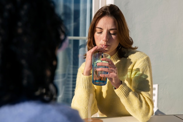 Gratis foto zijaanzicht vrouwen met smakelijke kombucha