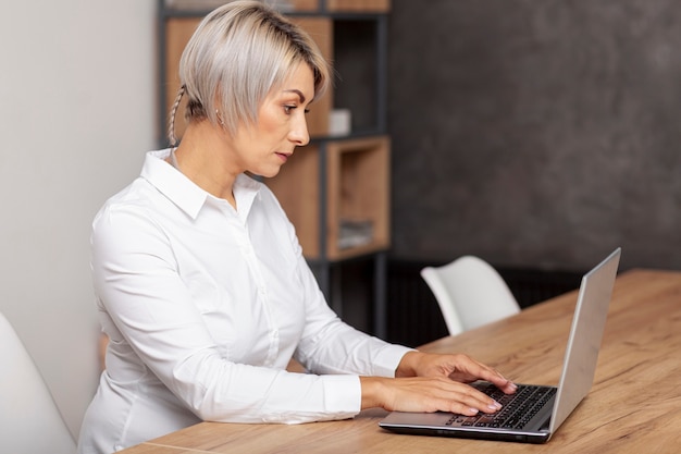 Zijaanzicht vrouwtje die op laptop werkt