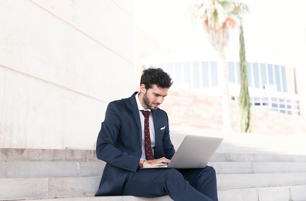 Gratis foto zijaanzicht werkende man zittend op trap