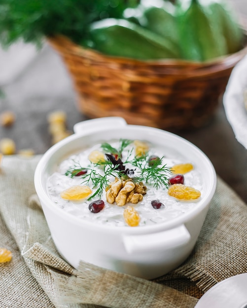 Zijaanzicht yoghurt met walnoten rozijnen en Groenen