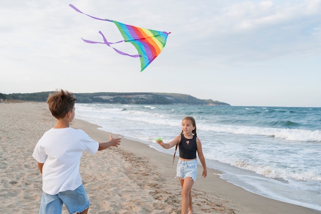 Gratis foto zijaanzichtkinderen die plezier hebben op het strand