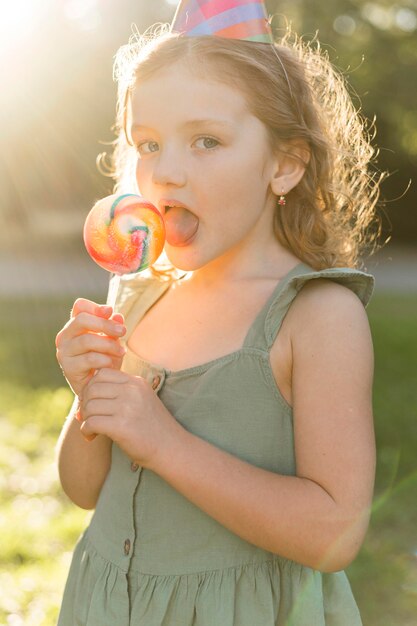 Zijaanzichtmeisje dat lolly eet