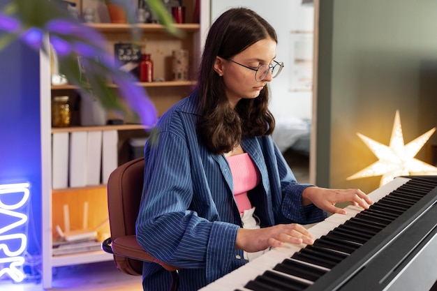 Gratis foto zijaanzichtmeisje dat piano speelt