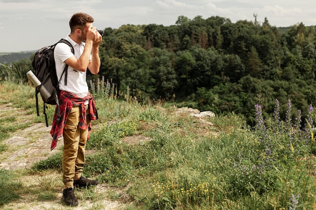 Gratis foto zijaanzichtmens die foto's nemen