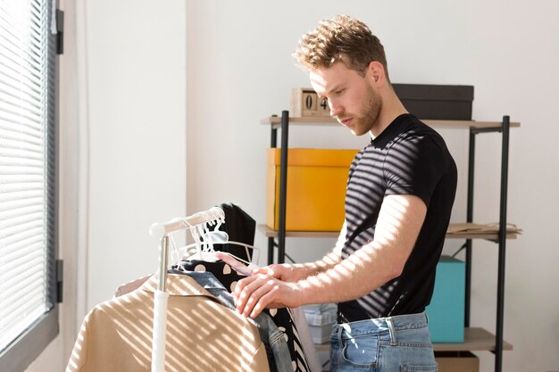 Zijaanzichtmens die kleren bekijken