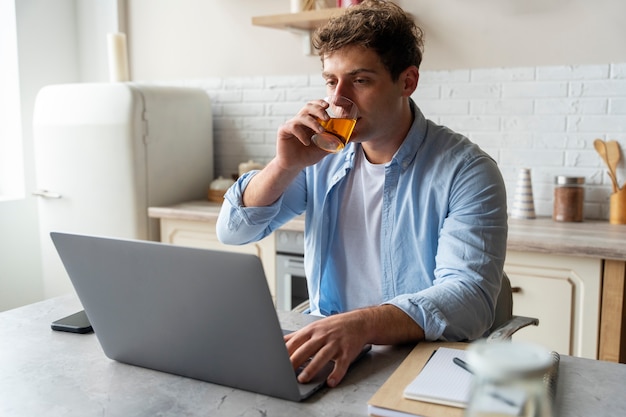 Gratis foto zijaanzichtmens die kombucha drinkt