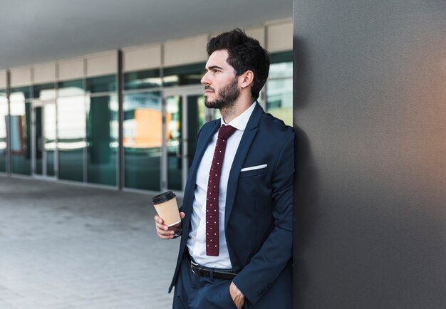 Zijaanzichtmens die met koffie weg kijken