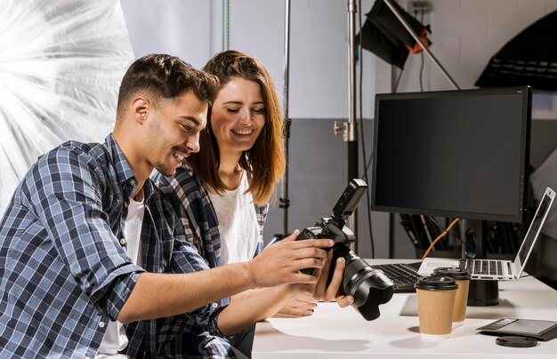 Zijaanzichtmensen die beelden op camera bekijken