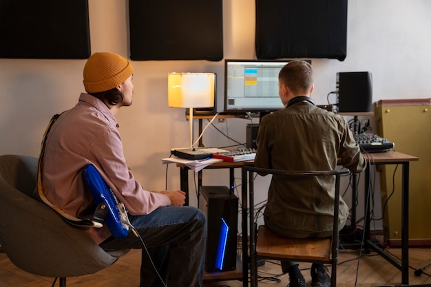 Gratis foto zijaanzichtmuzikanten die in de studio werken