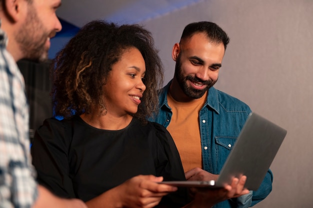 Zijaanzichtmuzikanten die met laptop werken