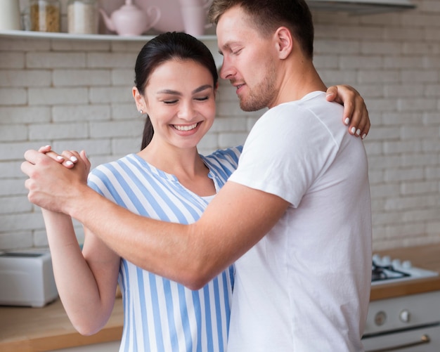 Gratis foto zijaanzichtpaar die binnen dansen