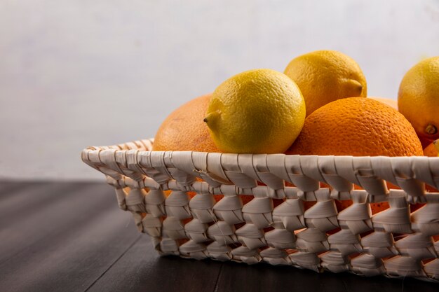 Zijaanzichtsinaasappelen in een mand met citroenen en grapefruits