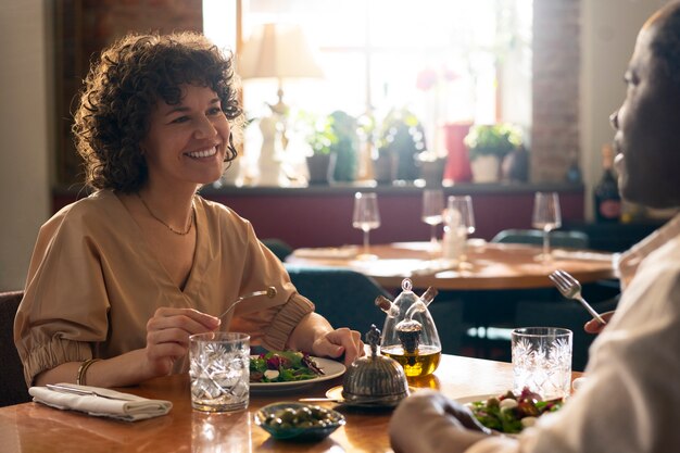 Zijaanzichtvrienden die bij restaurant eten