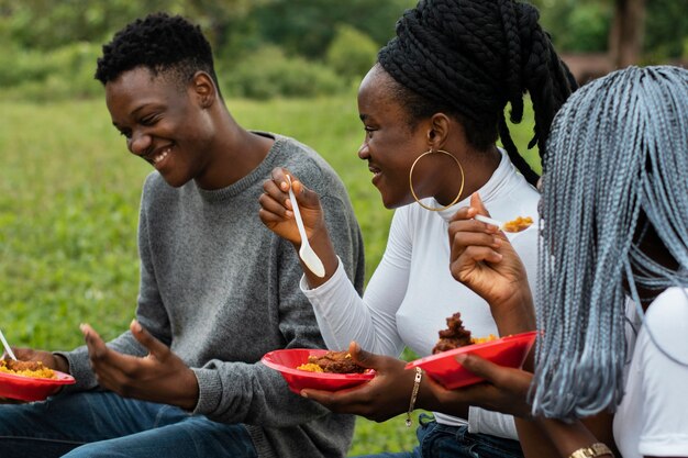 Gratis foto zijaanzichtvrienden die buiten lunchen