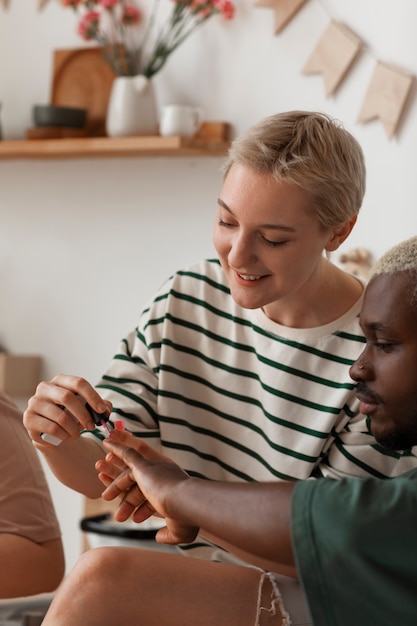 Gratis foto zijaanzichtvrienden die manicure krijgen