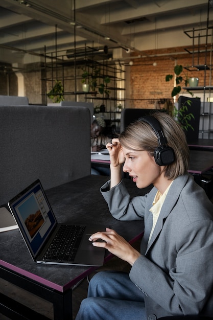 Gratis foto zijaanzichtvrouw die aan laptop werkt