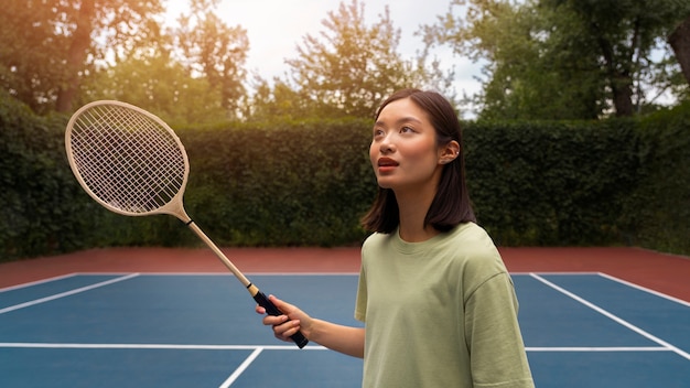 Zijaanzichtvrouw die badminton speelt