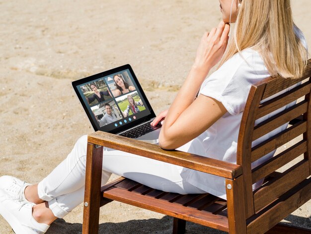 Zijaanzichtvrouw die buiten een videogesprek hebben